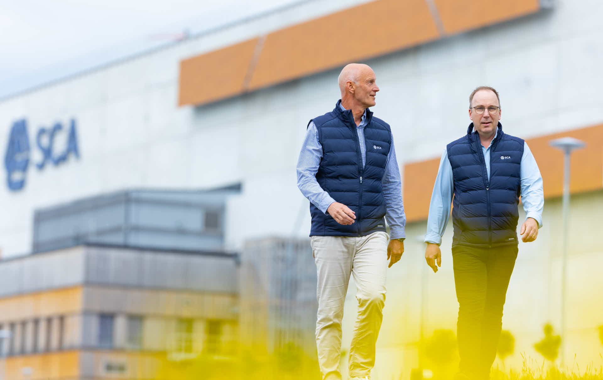 Two men walking outside the Obbola paper mill