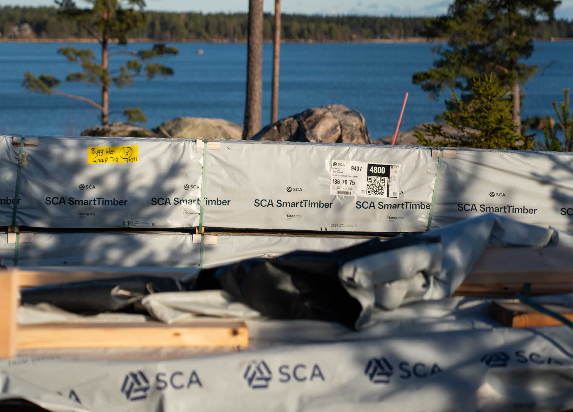 Loop70-plasten på virkespaket vid ett husbygge.