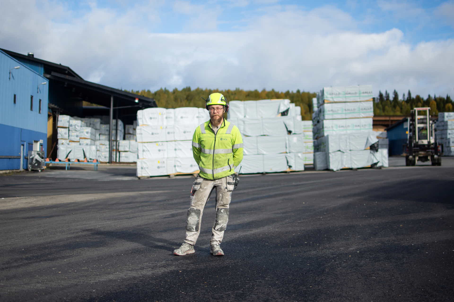 Porträttbild på Kim Wenman framför några träpaket.