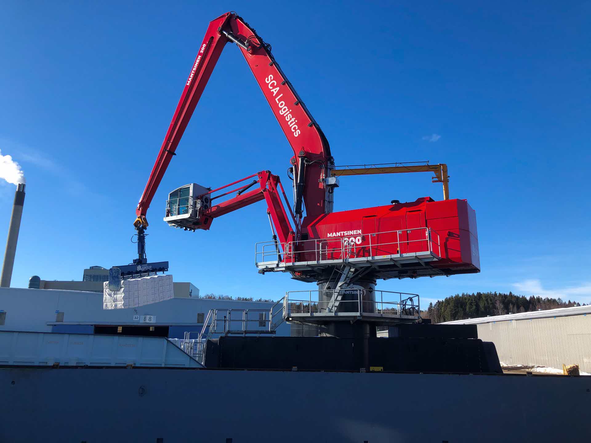 A crane loads bales of pulp in the port.