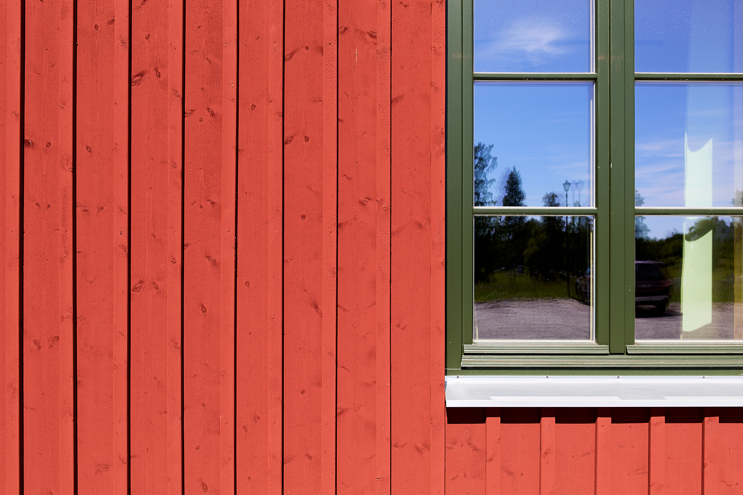 Närbild på en rödmålad ytterpanel från SCA SmartTimber.