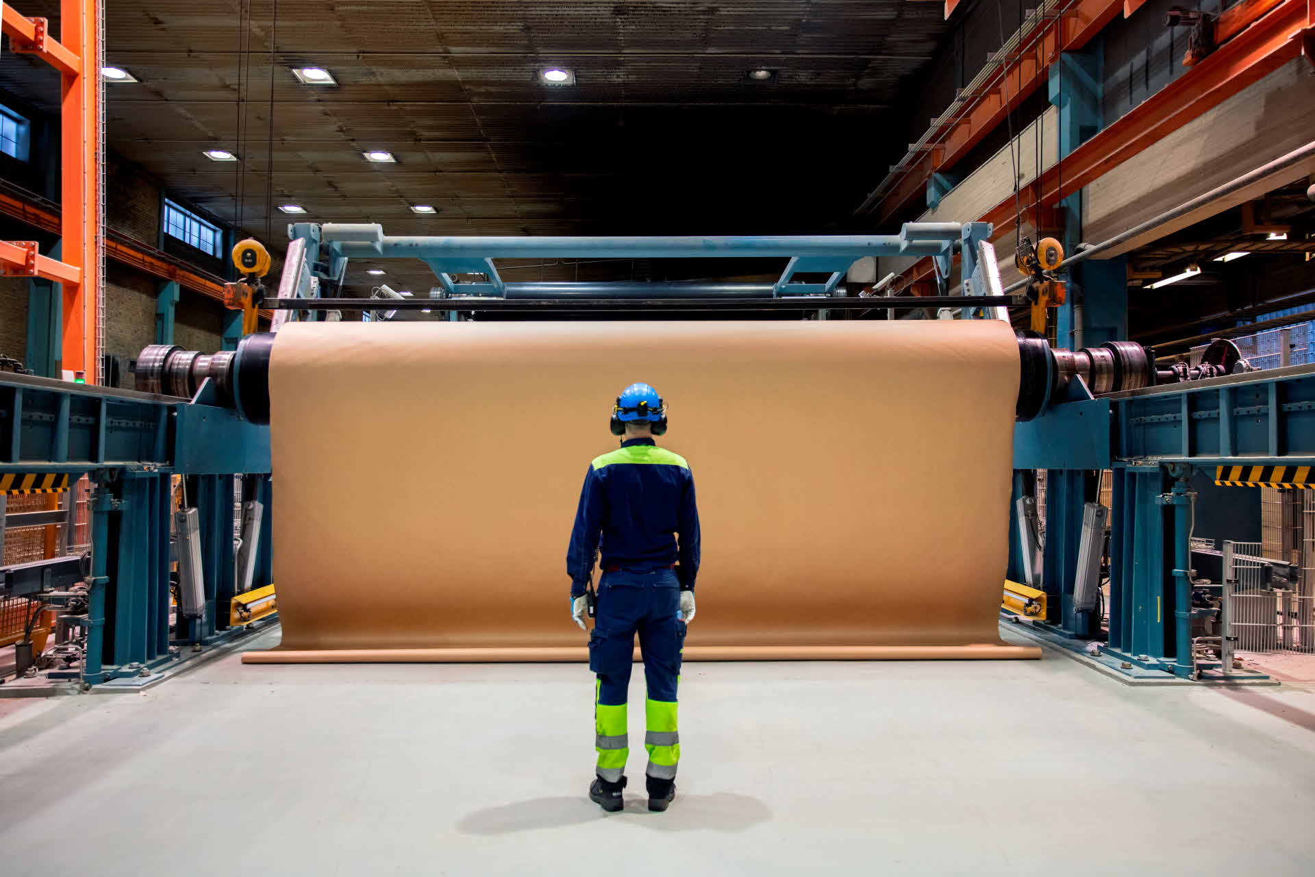 An employee next to a paper roll at the Munksund paper mill.