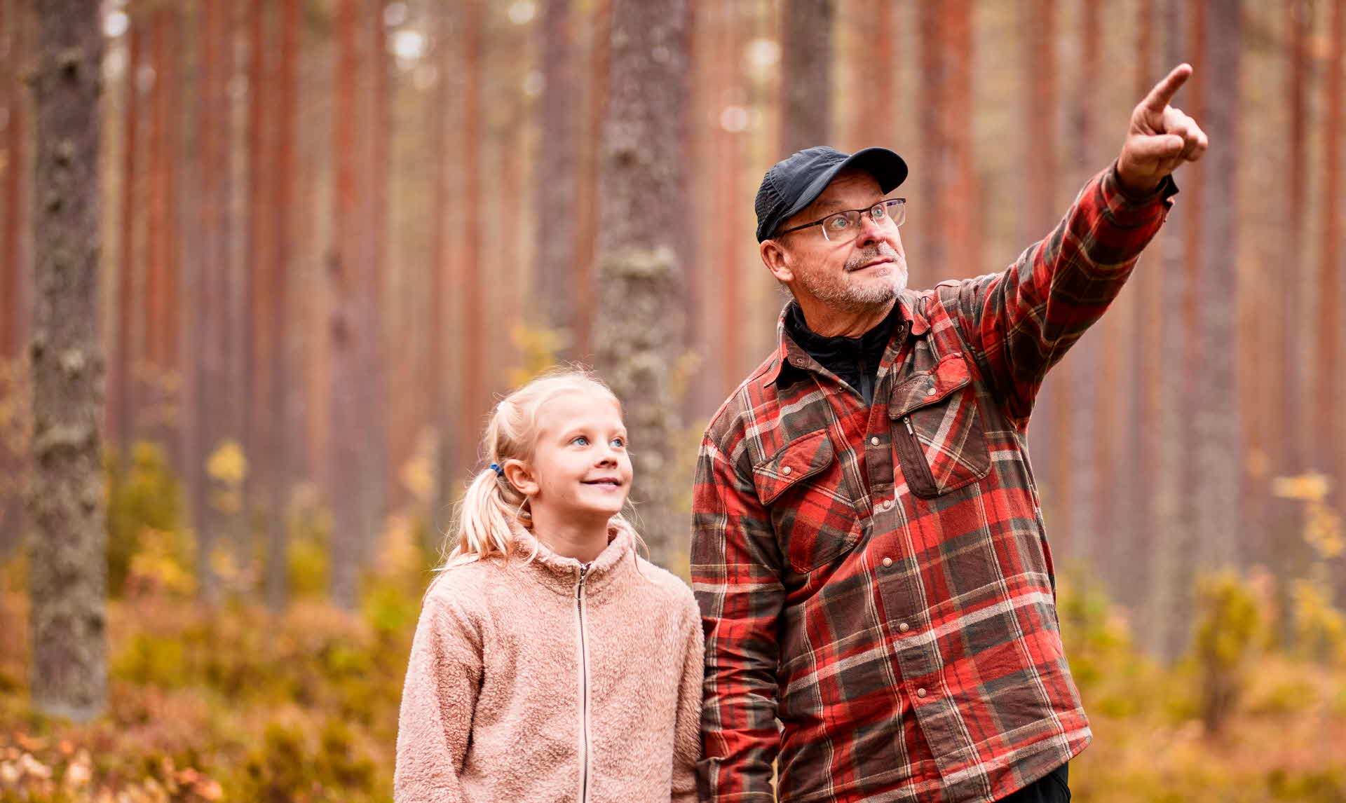 En närbild på två glada människor i skogen.