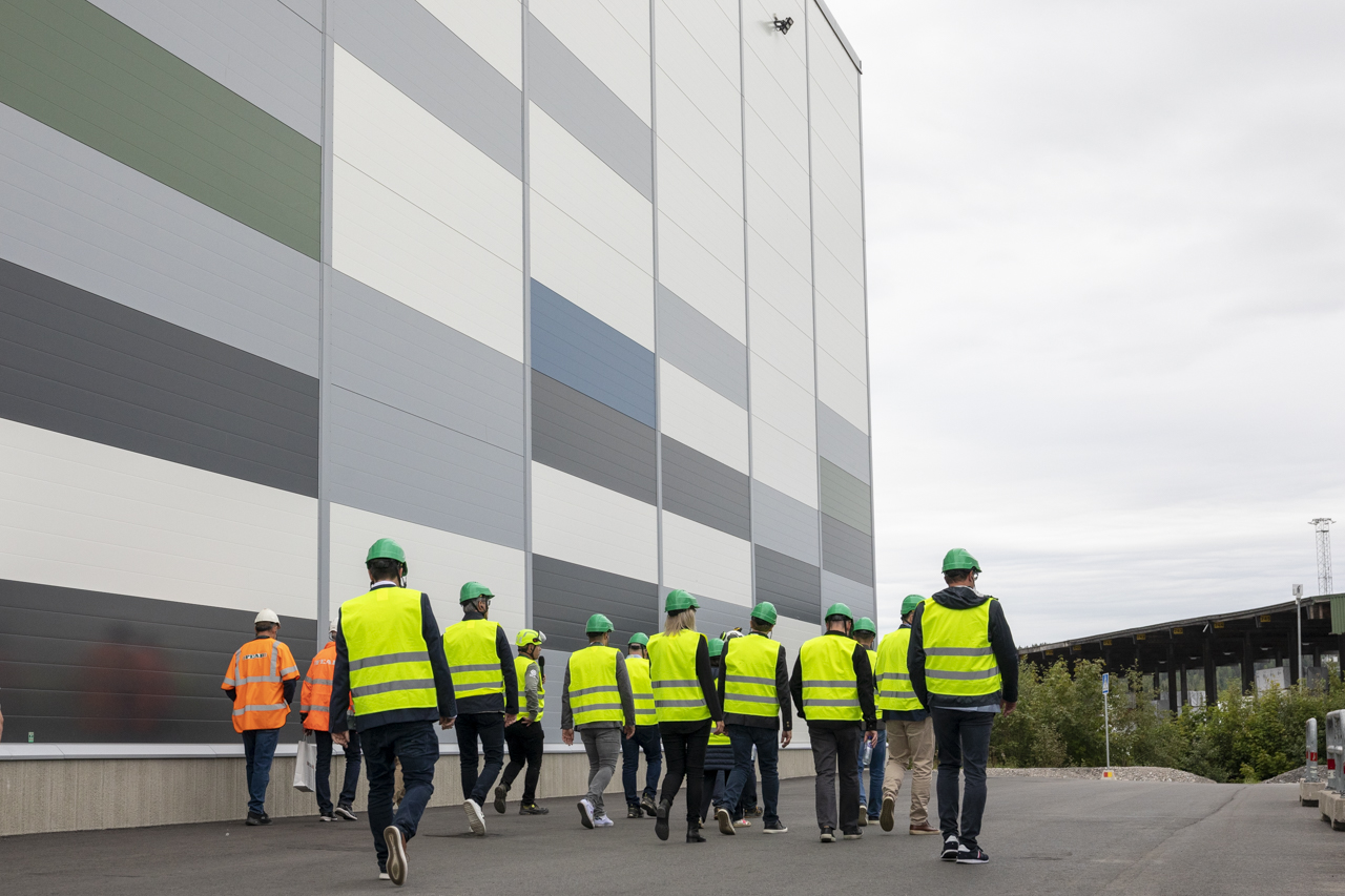 En grupp människor promenerar utanför bygganden till det nya justerverket.