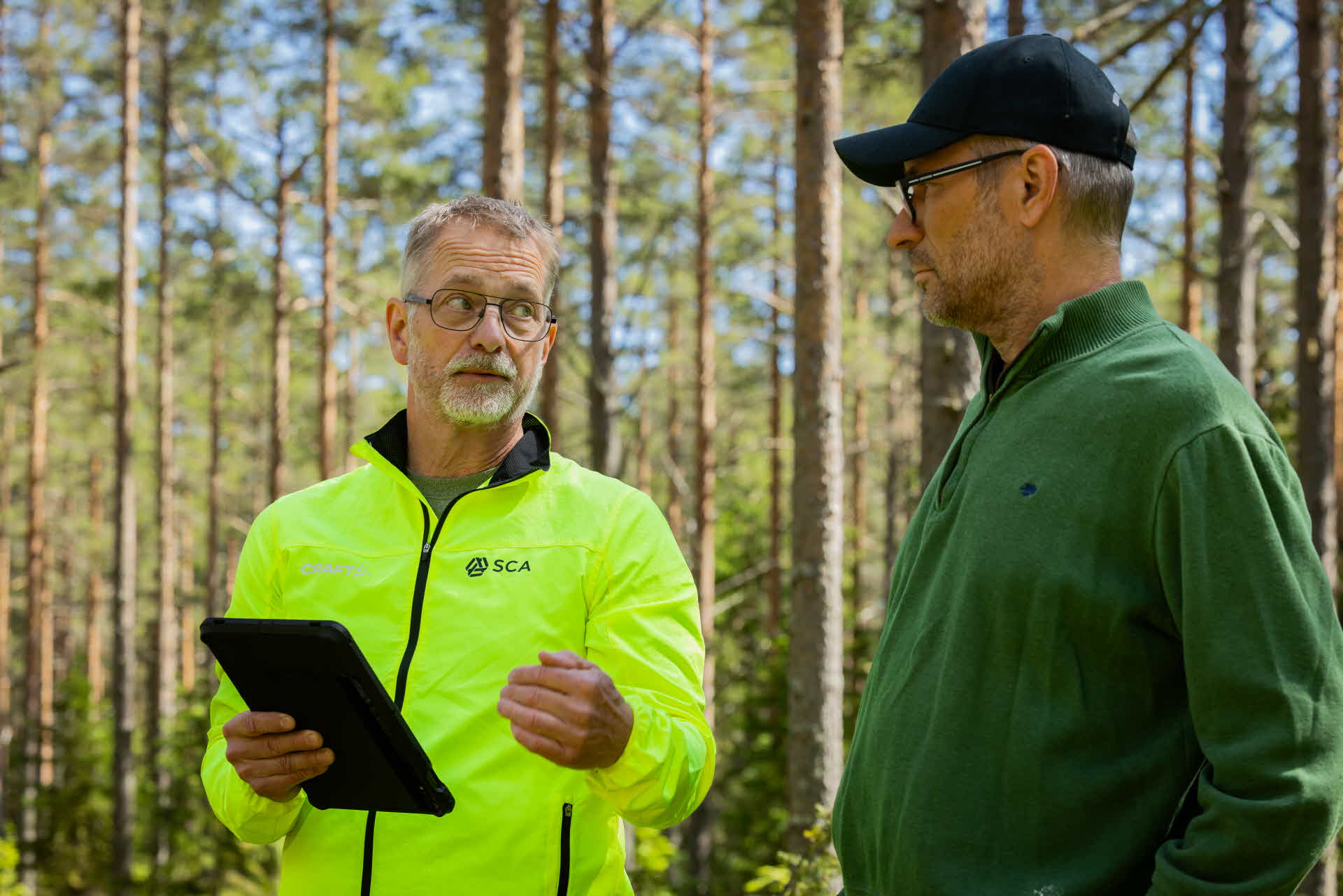 Två män samtalar i skogen