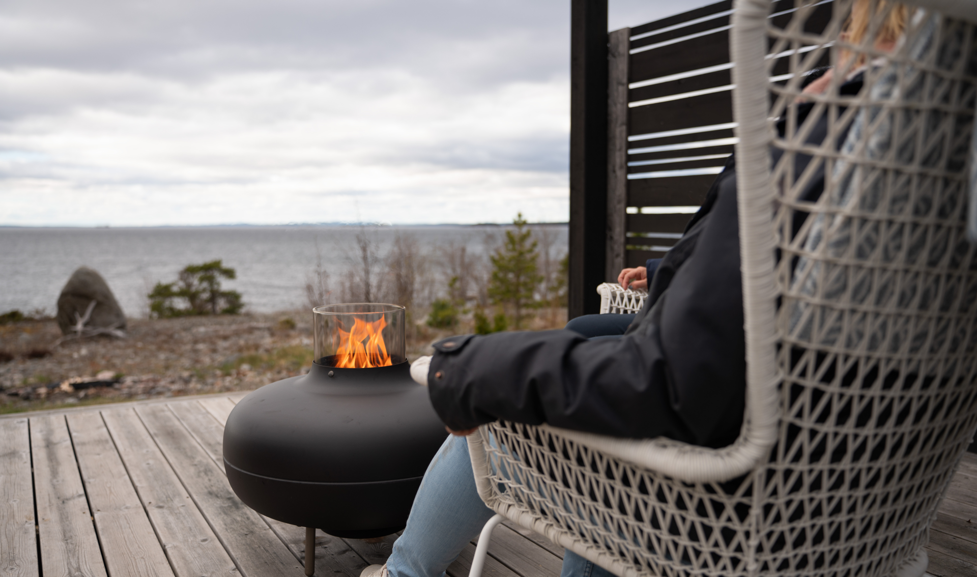 Pellets eldas i terassvärmare på ett trädäck vid havet.