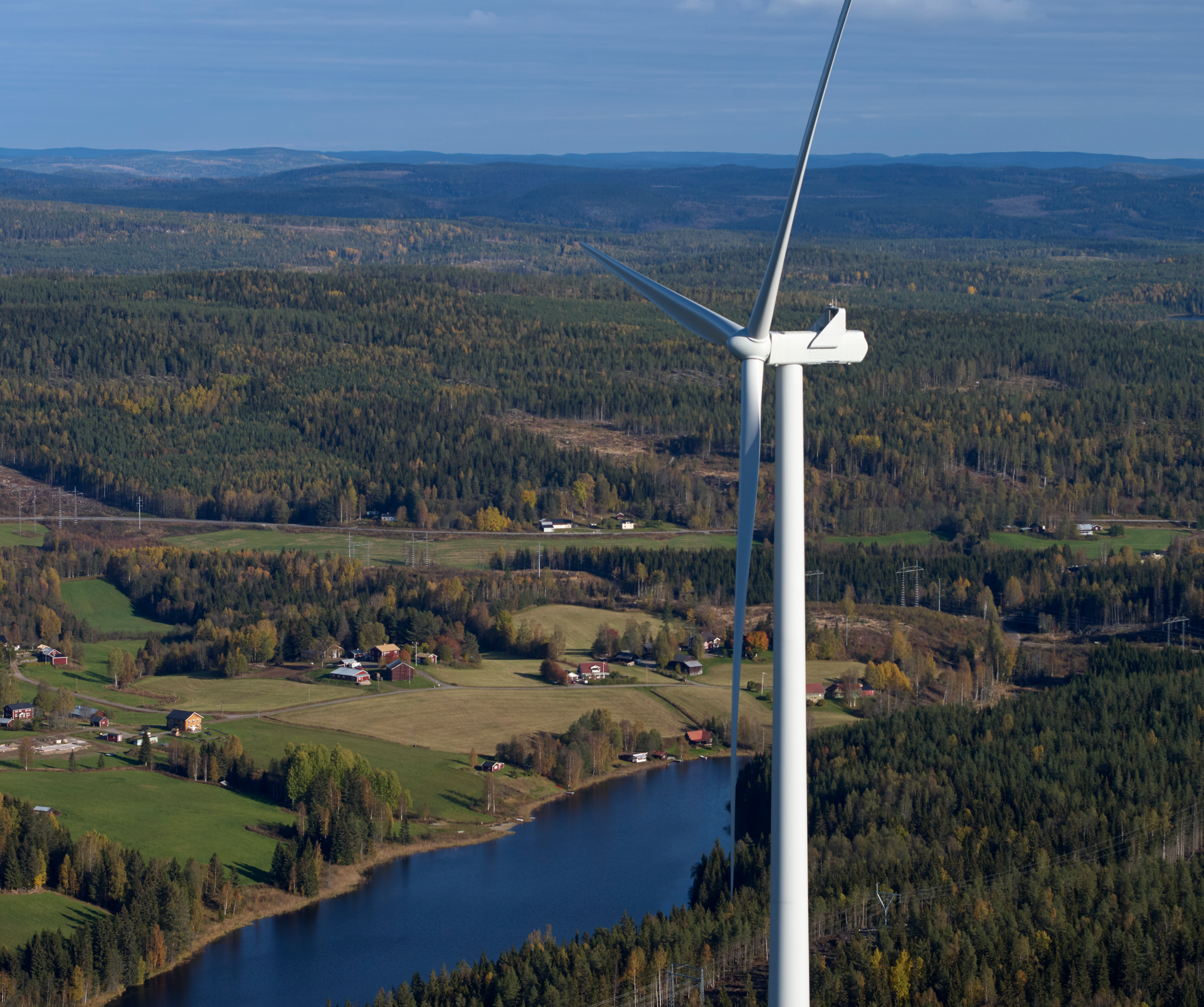 Vindkraftverk med bostäder i bakgrunden