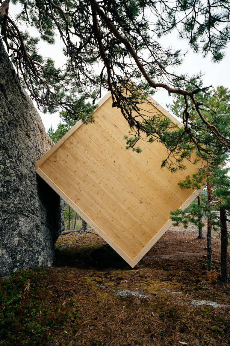 Vindskyddet står lutat mot ett stort stenblock.