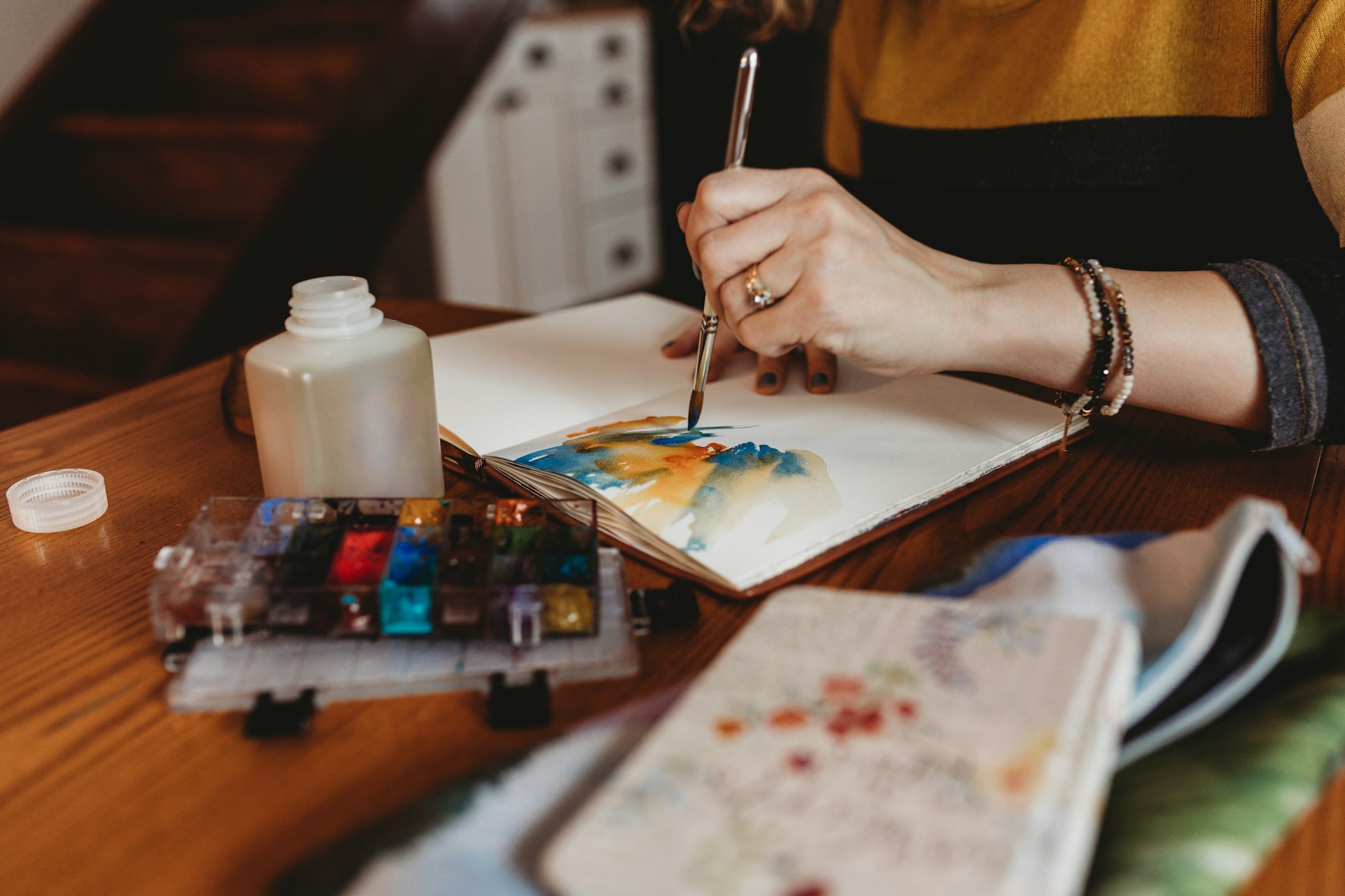 Sittande person som målar med vattenfärg.