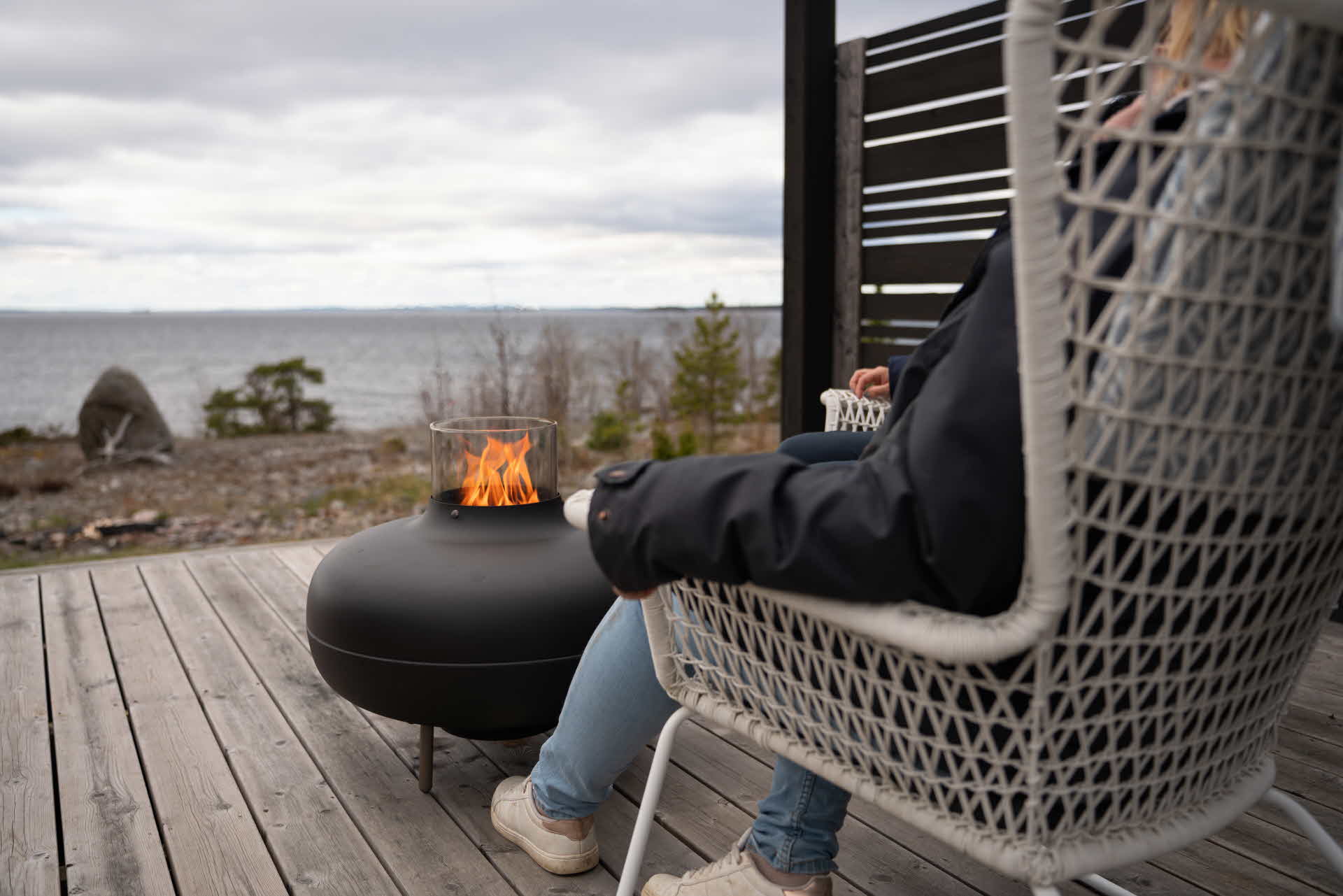 Pellets eldas i terassvärmare på ett trädäck vid havet.