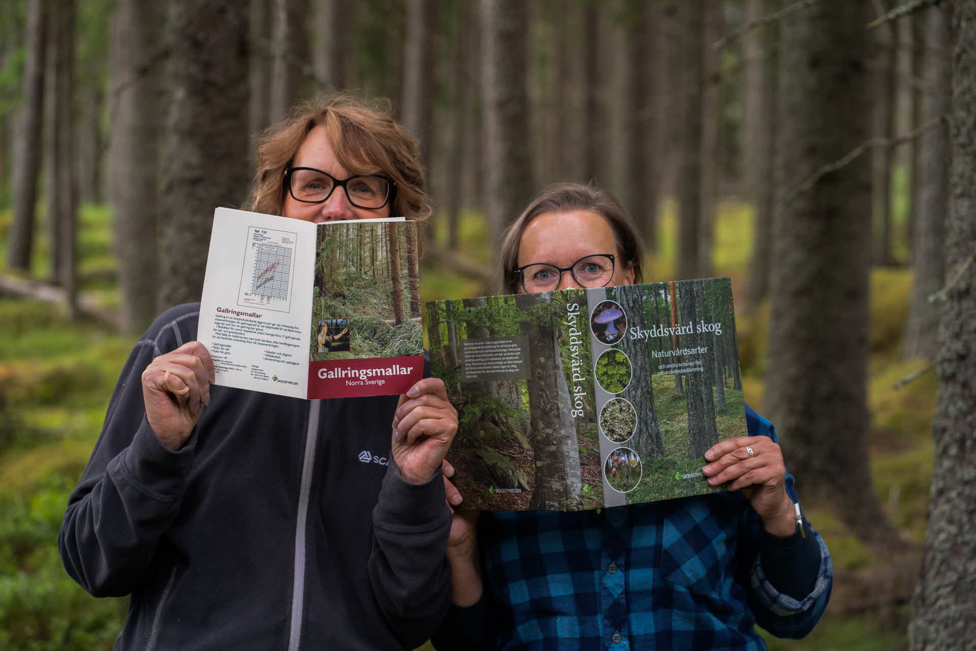 Systrarna Kerstin och Ylva kikar fram bakom kurslitteratur