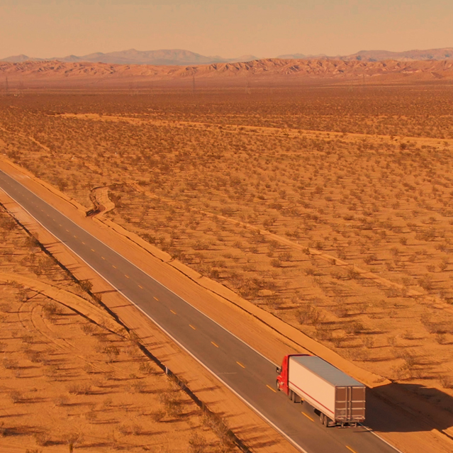 Truck driving through desert landscape