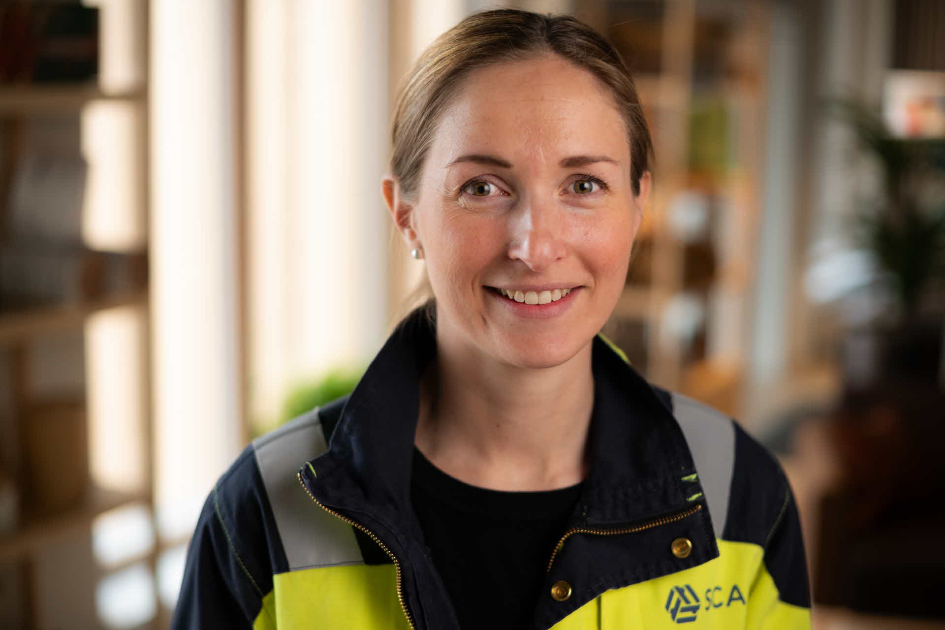 Porträttbild på en medarbetare i skogen.