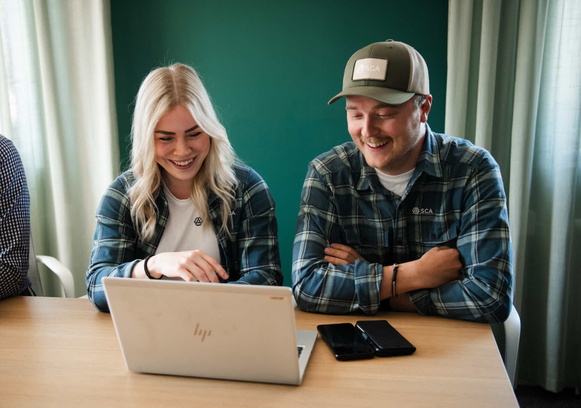 Två kvinnor ler och samtalar med varandra.
