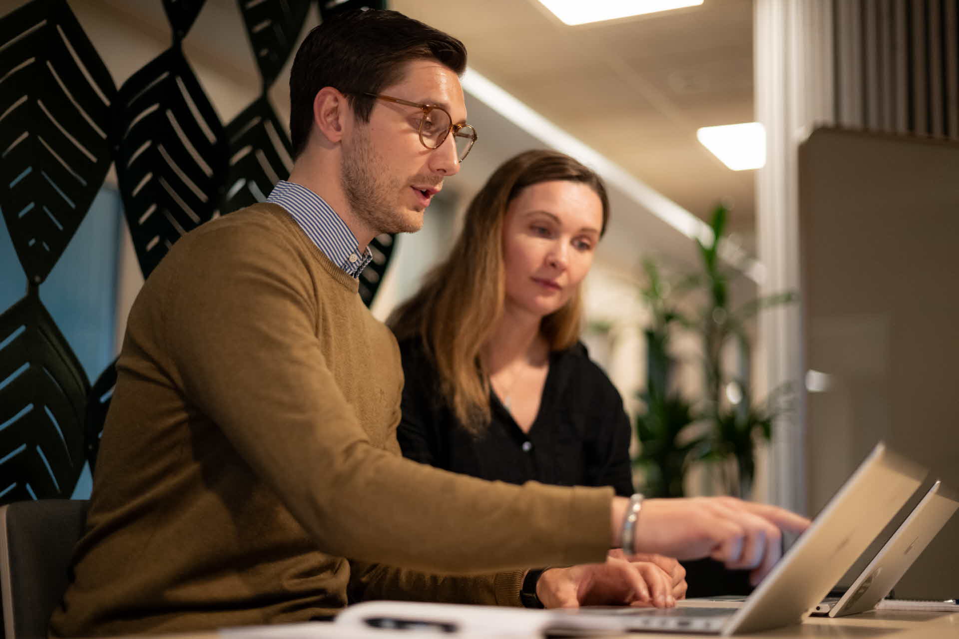 Two people working infront of laptop