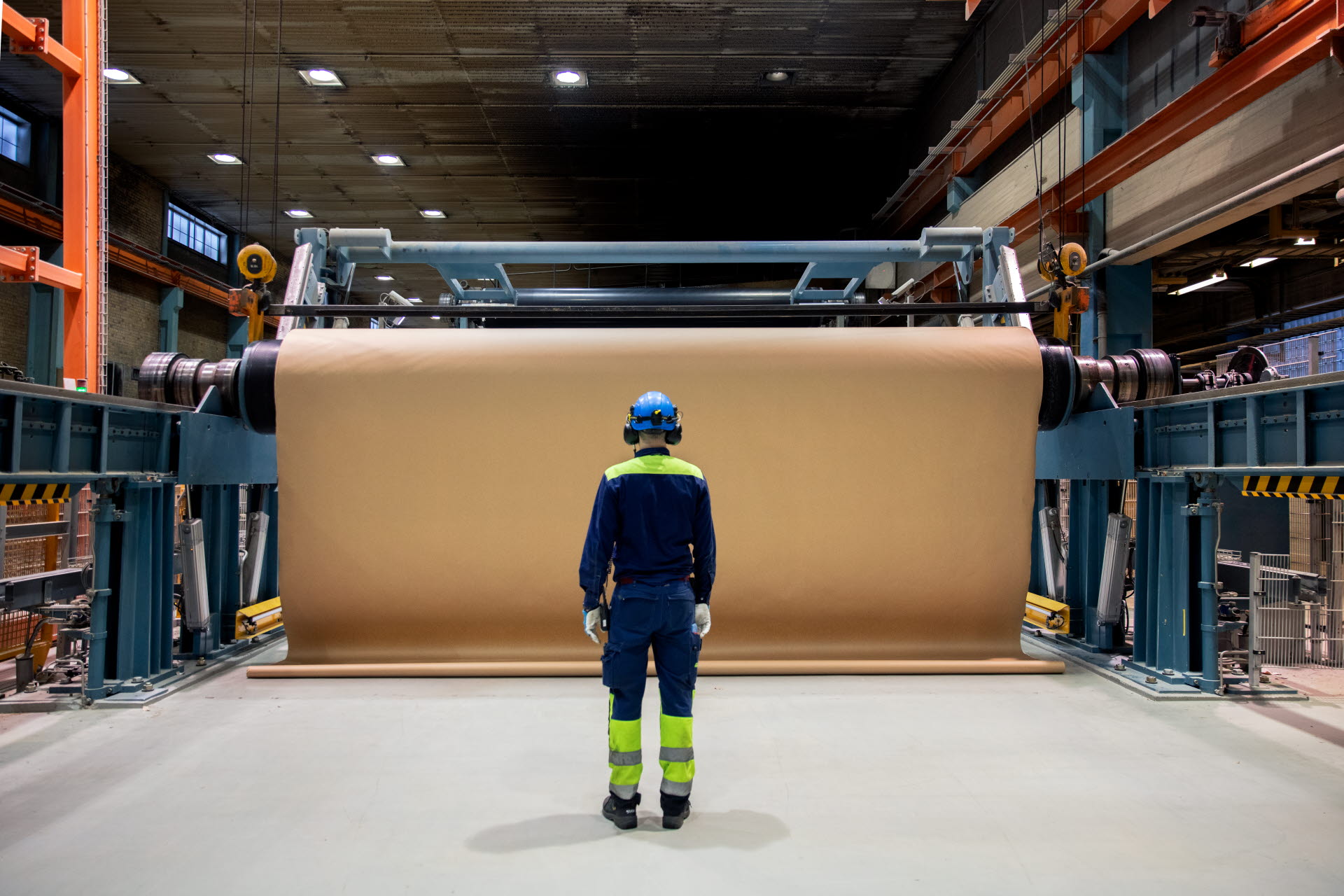 An employee next to a paper roll at the Munksund paper mill.