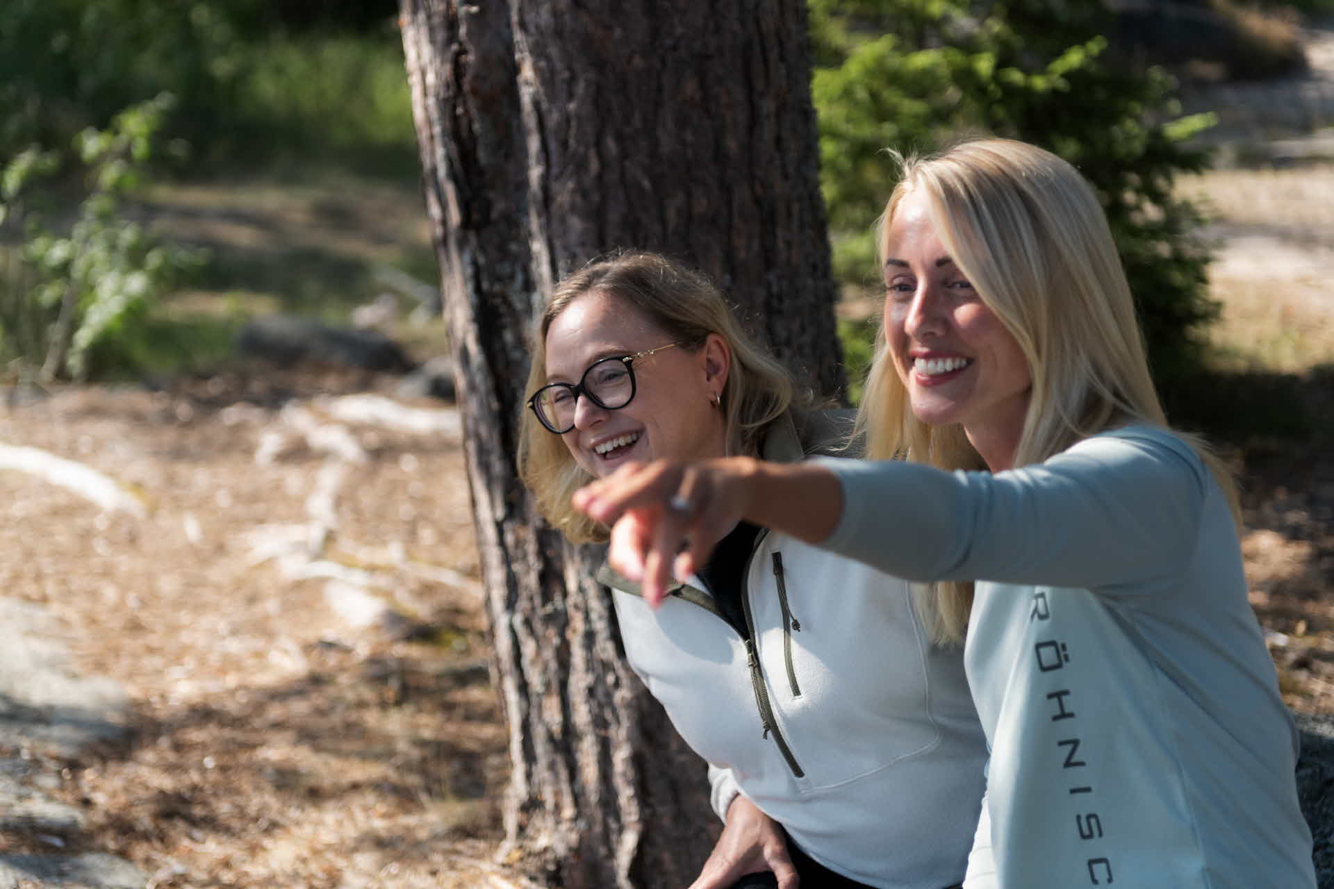 Två kvinnor sitter bredvid varandra och skrattar