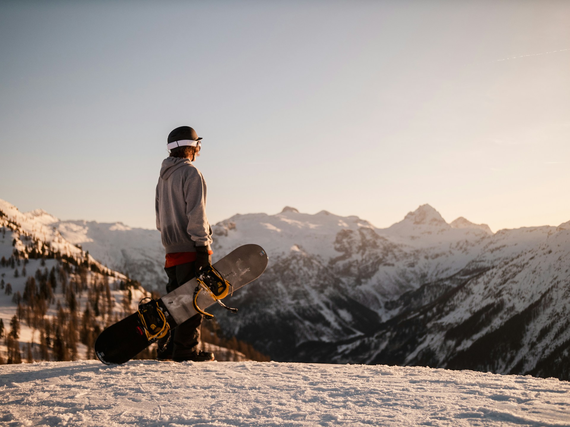 Snowboardåkare blickar ut över fjälltopparna.