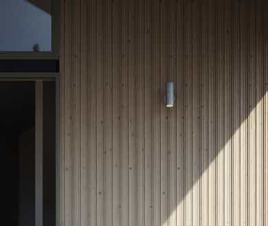 Ytterpanelen SCA Ursus monterad på ett hus. Med en bänk framför.