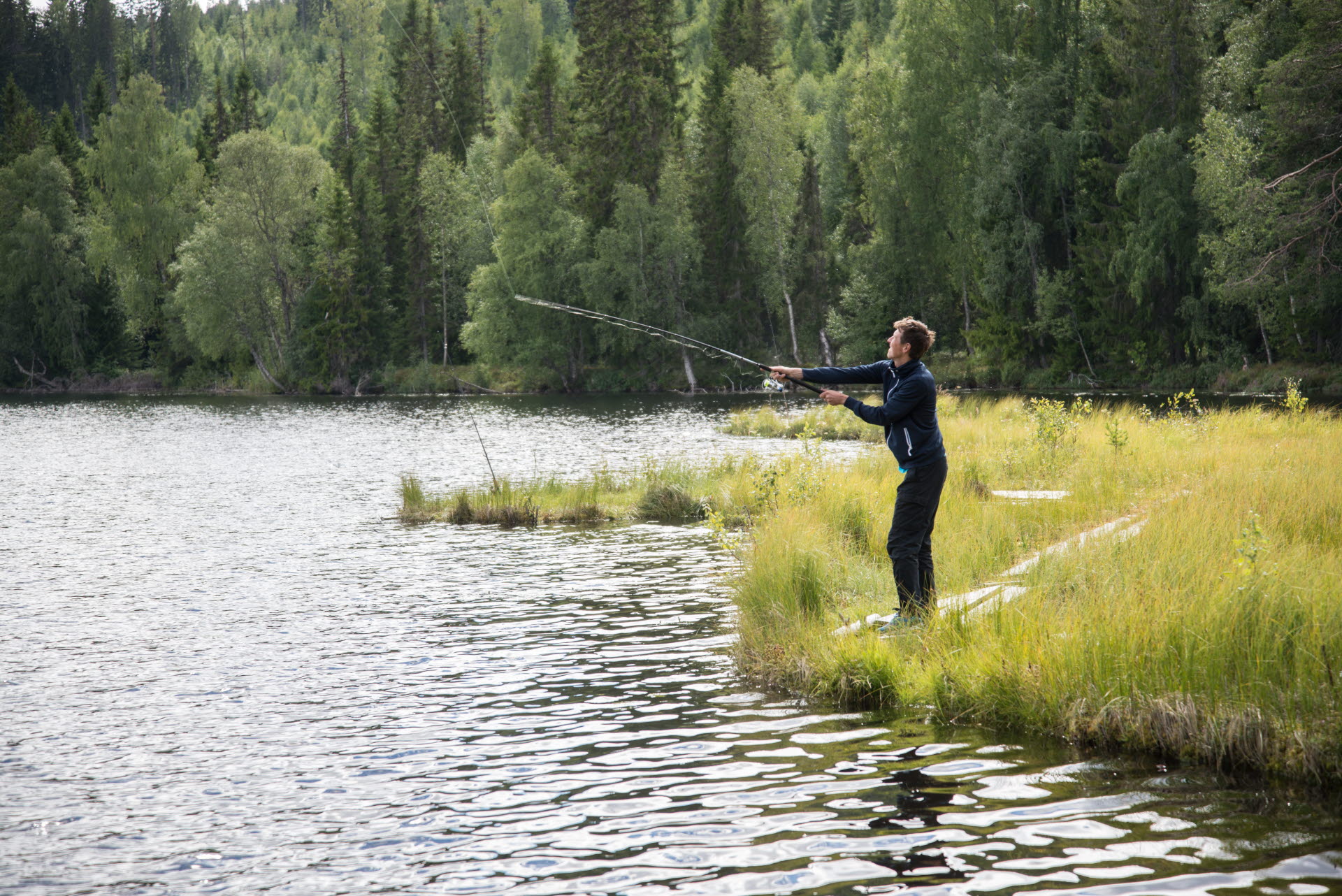Bilden visar visar en fiskare vid en sjö