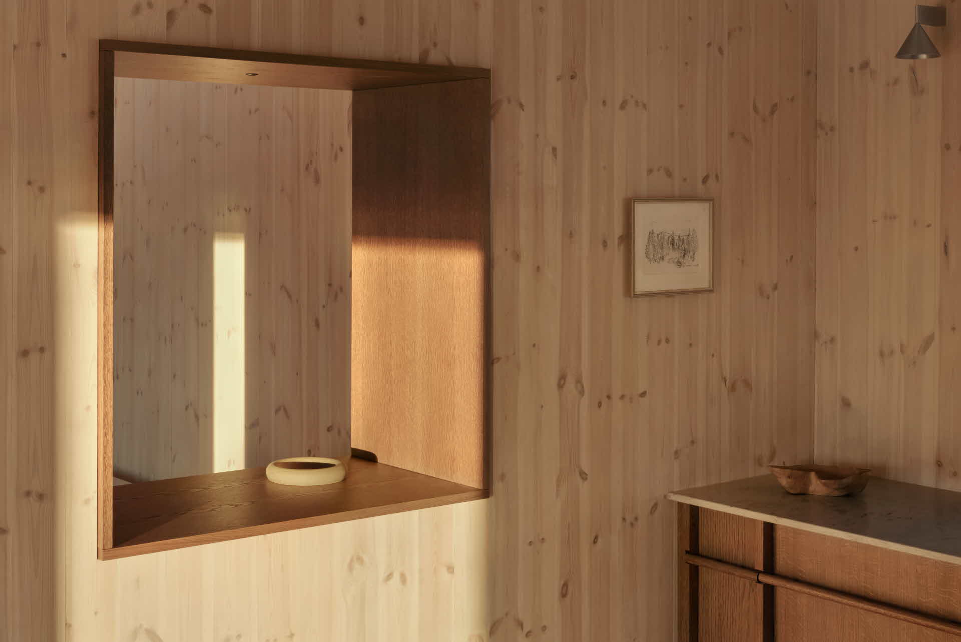 En träbeklädd innervägg som solens lyser upp.