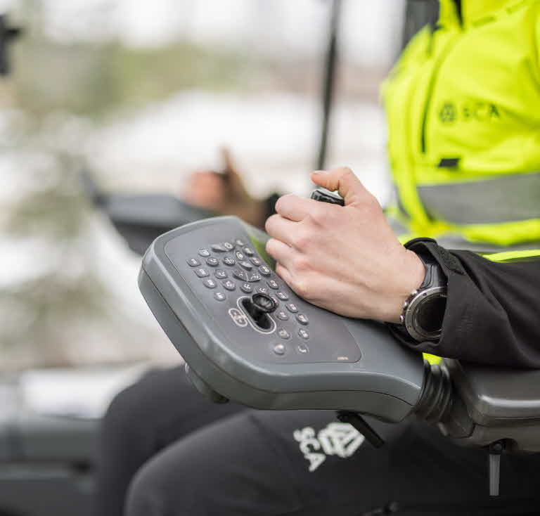 Hand på joystick i skogsmaskin