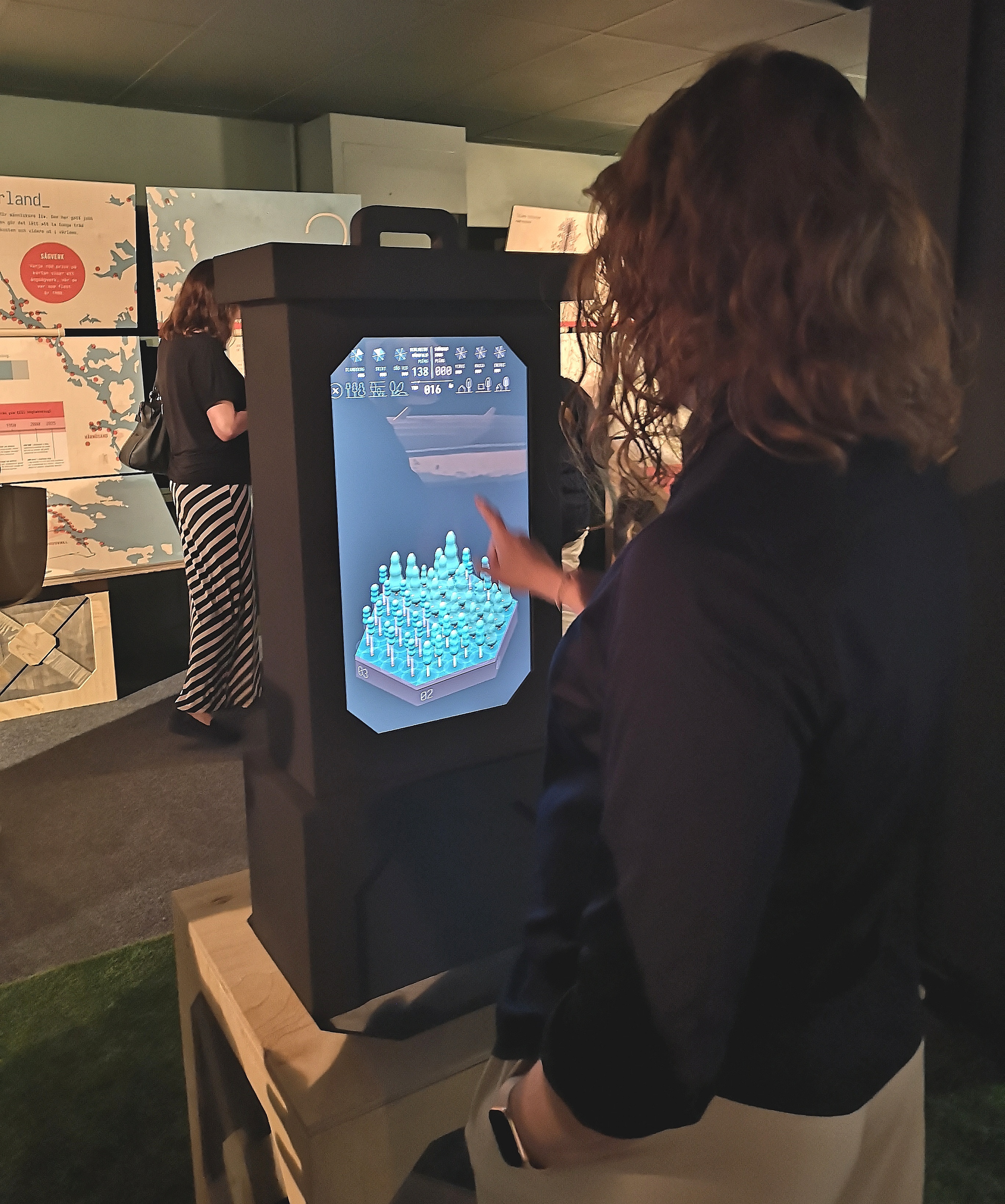 Technicus i Härnösand - tjej svarar på frågor om skogsbruk på en pekskärm.