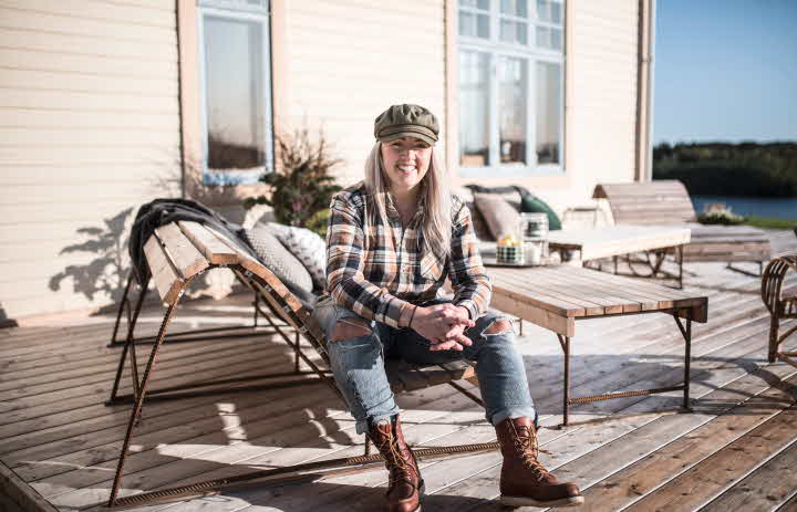 Petra Nyborg sitter på en benk laget av kjernefuru.