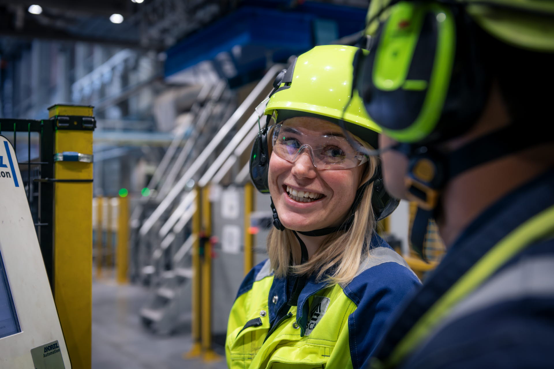 Close-up of a happy employee in an industrial setting.