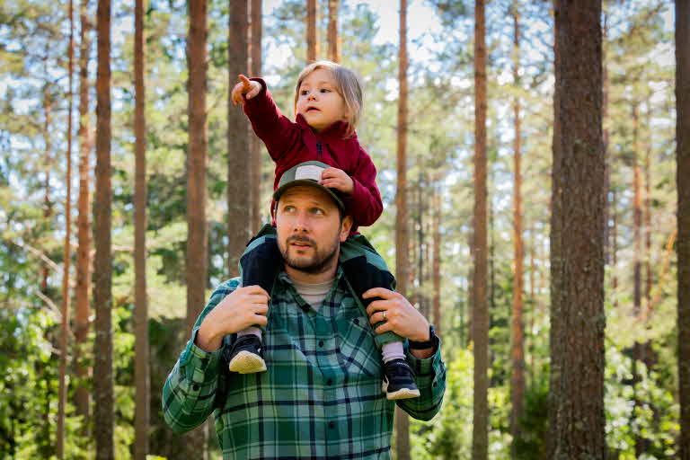 Pappa och barn i skogen